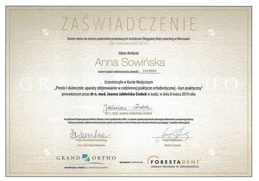 Certyfikat w języku polskim przyznany Annie Sowińskiej za ukończenie praktycznego kursu dotyczącego aparatów ortodontycznych, podkreślający Profesjonalne Leczenie Dentystyczne Kraków, podpisany i datowany na 8 marca 2019 r., z logo Grand Ortho i Forestadent.