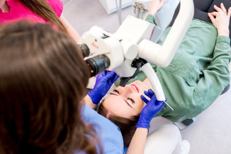 Dentystka przeprowadza badanie zęba pacjentki.