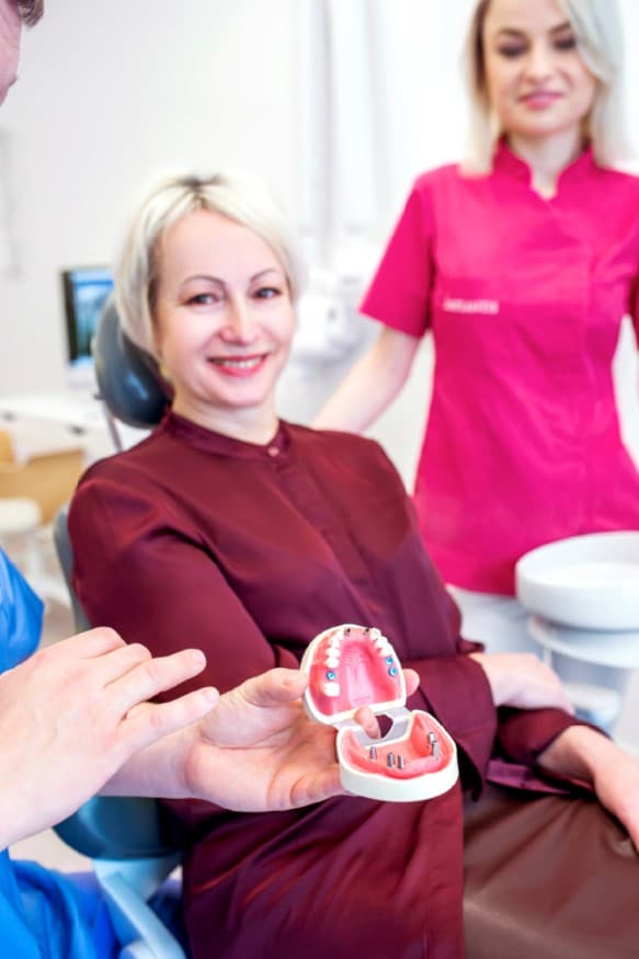 Pacjentka na fotelu u dentysty zadowolona z konsultacji u doktora Tomasza Marecika